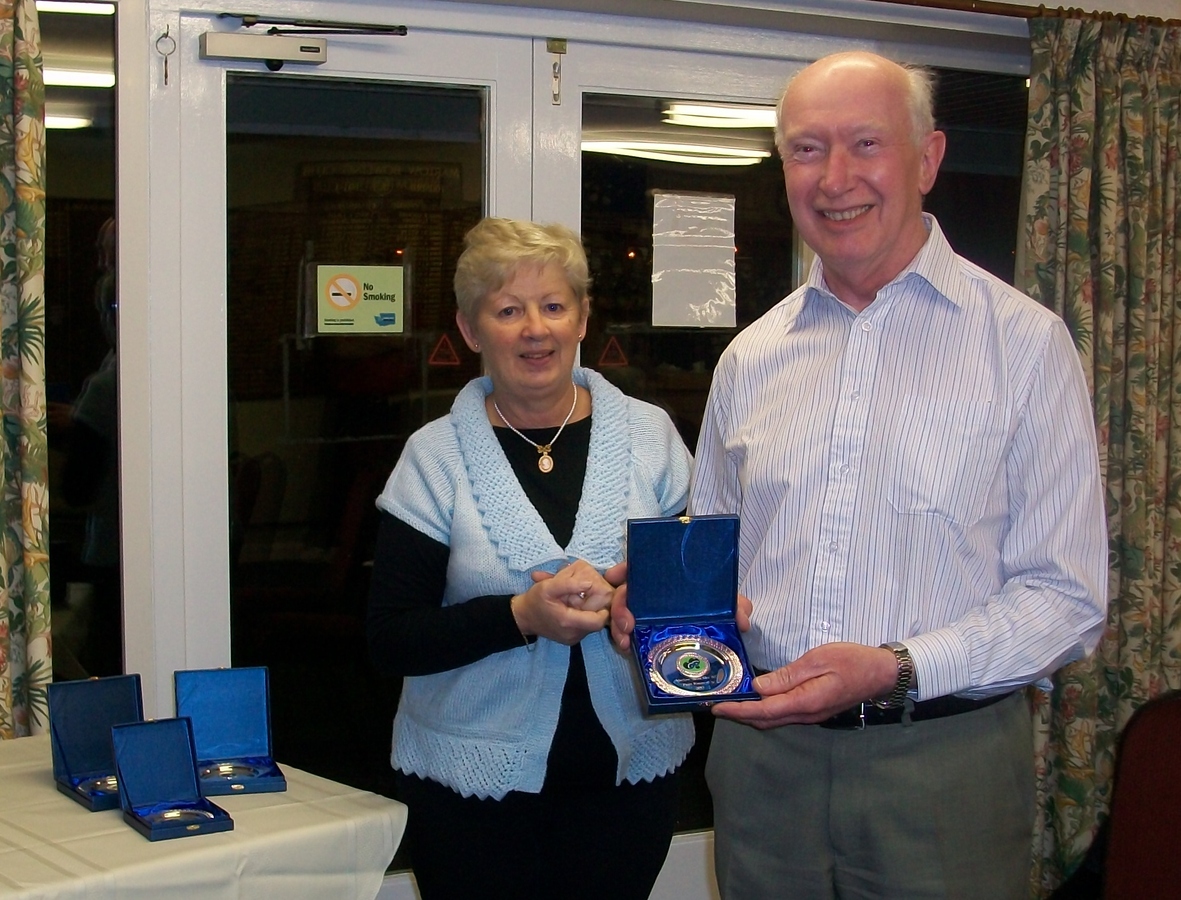 Pam Butler presenting Peter Barltrop with his trophy as a runner up in the Pairs